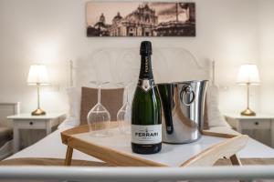 a bottle of champagne and two glasses on a table at Aulino House in Catania
