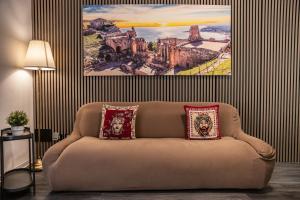 a couch in a living room with a painting on the wall at Aulino House in Catania +65 photos