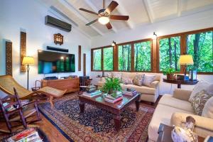 a living room with a couch and a tv at Las Margaritas, Casa de Campo in La Romana