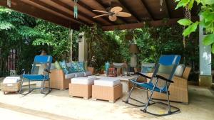 a patio with chairs and a couch and a ceiling at Las Margaritas, Casa de Campo in La Romana