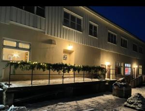 a building with a fence with christmas lights on it at Snertingdal ysteri in Gjøvik