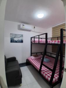 a bedroom with two bunk beds and a chair at Sorelle Bella Vita in Manolo Fortich
