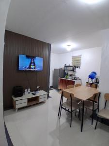 a living room with a table and a tv on a wall at Sorelle Bella Vita in Manolo Fortich