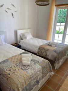 a bedroom with two beds and a window at Casa Lesarlo - T3 luxury, garden, pool - Praia D'El Rey in Casal da Lagoa Seca +9 photos