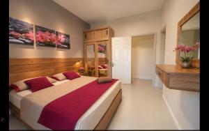 a bedroom with a large bed with red pillows at Beach luxury Penthouse in Flic-en-Flac +34 photos