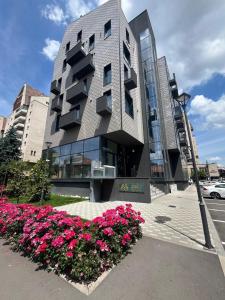 a building with pink flowers in front of it at Central View Penthouse & Parking in Târgu-Mureş