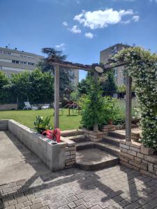 a garden with a pergola and two trees in a park at Maison à Macon in Mâcon