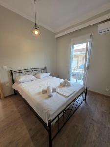 a bedroom with a bed with white sheets and a window at Center Twin Apartments - 2 in Chios