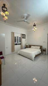 a white bedroom with a bed and a ceiling at Salem Fish Guest House in Al Ḩadd +85 photos