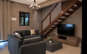 a living room with a couch and a flat screen tv at Beach luxury Penthouse in Flic-en-Flac