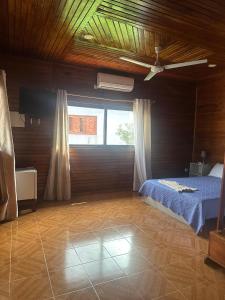 a bedroom with a bed and a large window at EcoResorTamarino in M. Peixe