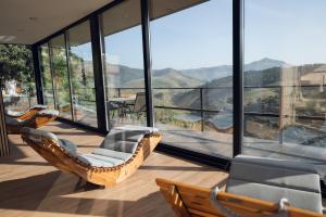 a balcony with chairs and a view of the mountains at Quinta da Portela Douro in Armamar