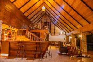 a large living room with a wooden ceiling with a staircase at Wild geese Lodge in Lulongo
