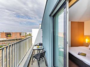 a balcony with a bed and a table at ibis Basel Bahnhof in Basel +73 photos