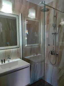 ein Badezimmer mit Glasdusche und Waschbecken in der Unterkunft Studios Spiros Parga in Parga
