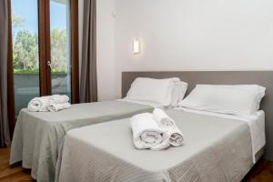 two beds with towels on them in a room at Appartamento dell'Aurora by Le Dune Villas in Porto Cesareo