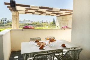 a white table with some food on a balcony at Appartamento dell'Aurora by Le Dune Villas in Porto Cesareo