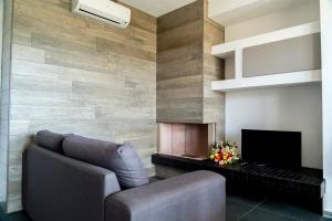 a living room with a couch and a television at Appartamento dell'Aurora by Le Dune Villas in Porto Cesareo