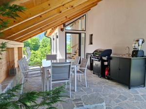 a patio with white chairs and a table and a stove at Murka Holiday Home in Bled