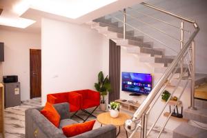 a living room with a staircase and a red couch at SARALIS Home in Abidjan