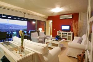 a living room with white couches and a television at Villa Salobre Master and Sun in Maspalomas