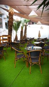 a room with chairs and tables and palm trees at Camping San Javier in San Javier