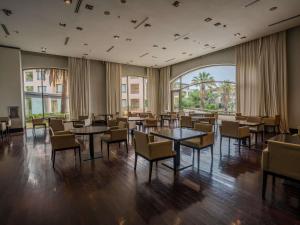 a restaurant with tables and chairs and a large window at Sofitel La Reserva Cardales in Río Luján