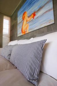 a bed with a black and white pillow and a painting at Villa Salobre Master and Sun in Maspalomas