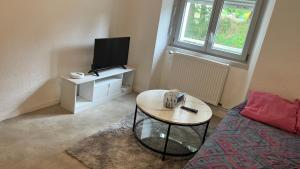 a small living room with a table and a tv at Ancrage home in Montargis