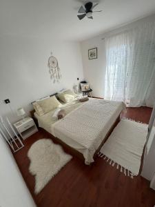 a bedroom with a bed and two rugs at Donna Seahouse in Jadranovo