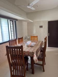 a dining room table with chairs and a tableclotholitics at JSP OLIVE NEST villa in Yelagiri