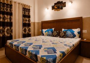 a bedroom with a bed with a blue and white quilt at Nature View Retreat in Rishīkesh