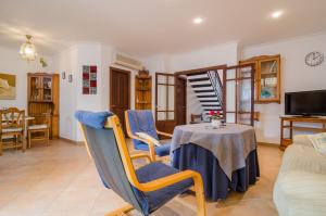 a living room with a table and blue chairs at Na Llebrona in Porto Cristo