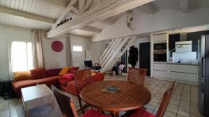 a living room with a table and a couch at Maison Barbâtre in Barbâtre +4 photos
