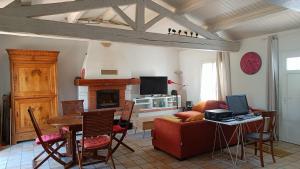 a living room with a red couch and a table with a television at Maison Barbâtre in Barbâtre