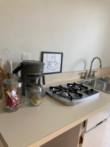 a kitchen counter with a coffee maker next to a sink at Queen Deluxe Double at Boundless Bliss Hotel in Raphune