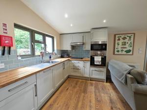 a kitchen with white cabinets and a wooden floor at 3 Bed in Lambourn oc-w42717 in Lambourn +12 photos