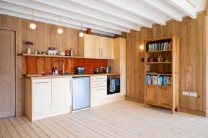 a kitchen with wooden cabinets and a sink and a book shelf at 1 Bed in Lambourn oc-b42716 in Lambourn +6 photos