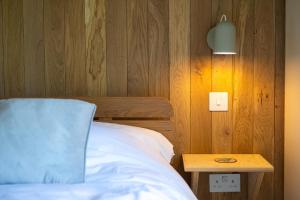 a bedroom with a bed and a wooden wall with a table at 1 Bed in Lambourn oc-b42716 in Lambourn