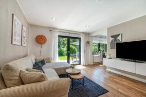 a living room with a couch and a flat screen tv at Design-Apartment mit Garten in Langenbach