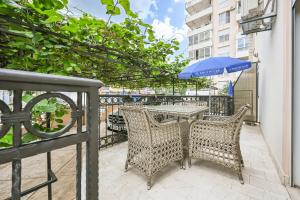 an outdoor table and chairs with an umbrella on a balcony at Apartmani Aleks in Budva