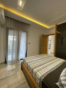 a bedroom with a bed and a large window at Résidence saint germain in Kelibia