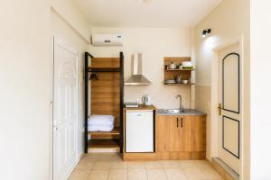 a small kitchen with a sink and a mirror at Nikos Villas - Poolside Getaways in Kavos, Corfu in Kavos