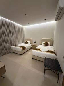 two beds in a room with white walls at ايا ان AYA Inn in Jeddah +23 photos
