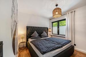 a bedroom with a large bed and a window at Design-Apartment mit Garten in Langenbach