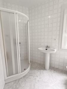 ein weißes Badezimmer mit Dusche und Waschbecken in der Unterkunft A Esteva in Orol