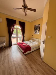 a bedroom with a bed and a ceiling fan at Y Panzió in Balatonlelle