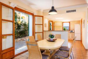 a kitchen and dining room with a wooden table and chairs at Cala Pi One in Cala Pi