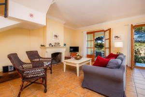 a living room with a couch and chairs and a fireplace at Cala Pi One in Cala Pi
