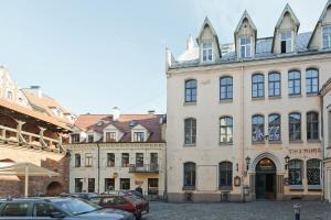 a group of buildings in a street with cars parked at Riga Old Town Jāņa Sēta Residence in Rīga
